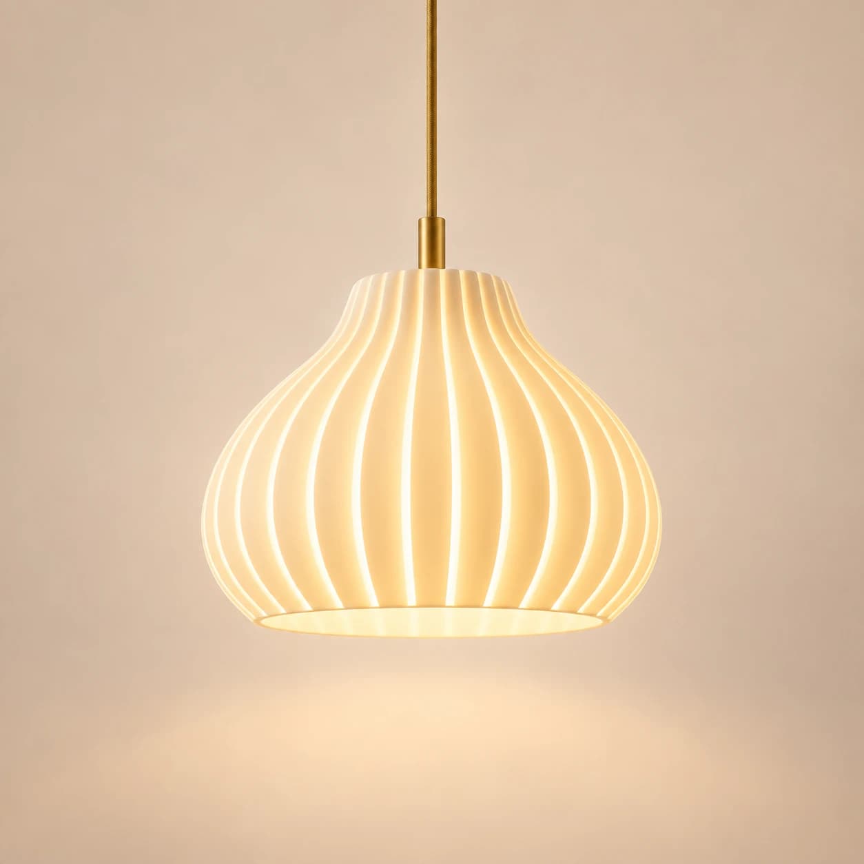 The Glow Bloom pendant light lit, hanging from a braided cord on a brass-finished fitting
